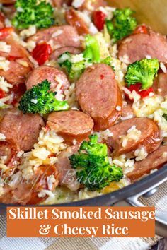 a skillet filled with sausage, rice and broccoli on top of a table