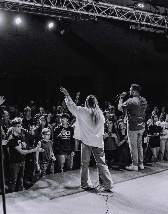 a man standing on top of a stage in front of a crowd