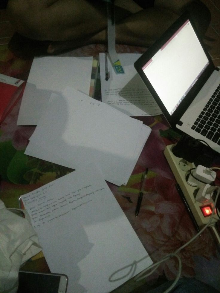 an open laptop computer sitting on top of a table covered in papers and other items