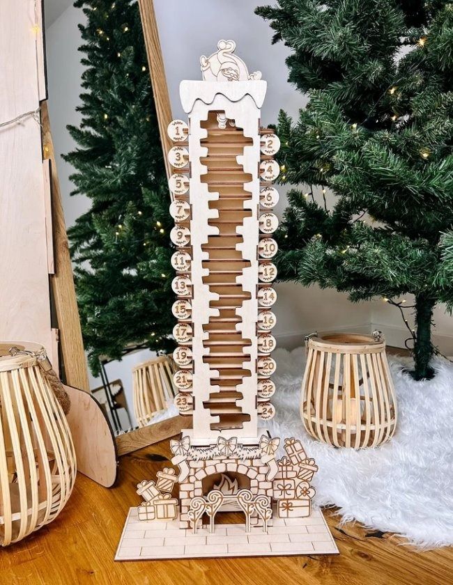 a wooden musical instrument sitting on top of a table next to a christmas tree and other decorations