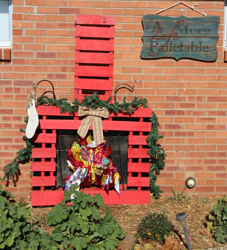 a red brick fire place with wreaths and stockings hanging on it's sides