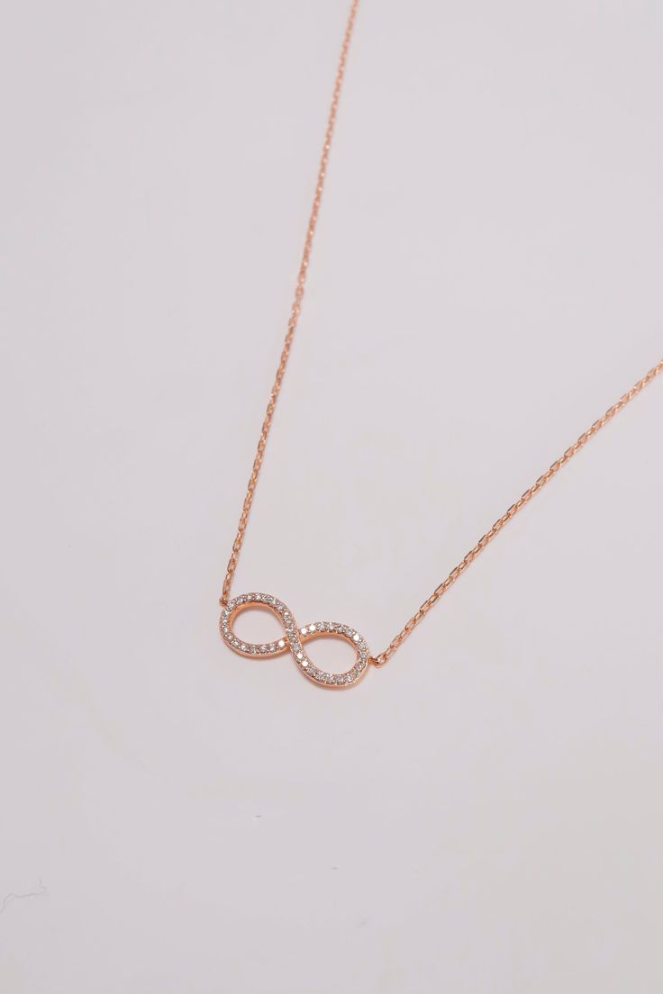 PLX501 (DS1024N) Celebrate eternal love and connection with our Handmade 14K Rose Gold Diamond Infinity Charm Necklace. This exquisite necklace features an infinity symbol charm adorned with natural diamonds, symbolizing everlasting bonds and infinite possibilities. Crafted from 14K rose gold, the necklace exudes a warm and romantic allure. The infinity charm is intricately designed, with each diamond expertly set to create a dazzling display of brilliance. The natural diamonds add a touch of sp Elegant Rose Gold Infinity Necklace, Dainty Infinity Rose Gold Necklace, Dainty Rose Gold Infinity Necklace, Luxury Rose Gold Infinity Jewelry, Rose Gold Infinity Necklace For Anniversary, Infinity Necklace With Diamond Accents, Rose Gold Infinity Jewelry With Diamond Accents, Dainty Rose Gold Infinity Jewelry, Anniversary Rose Gold Necklace With Si Clarity