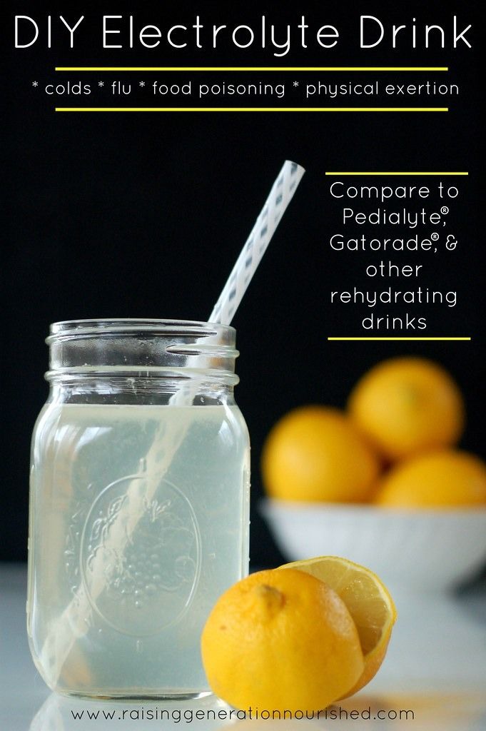 a mason jar filled with liquid next to some lemons and a straw in it