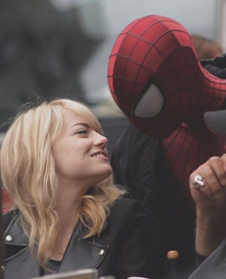 a man and woman sitting next to each other in front of a spider - man