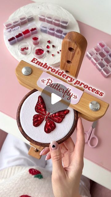 a person holding a wooden object with red butterflies on it and the words embroidery process in front of them