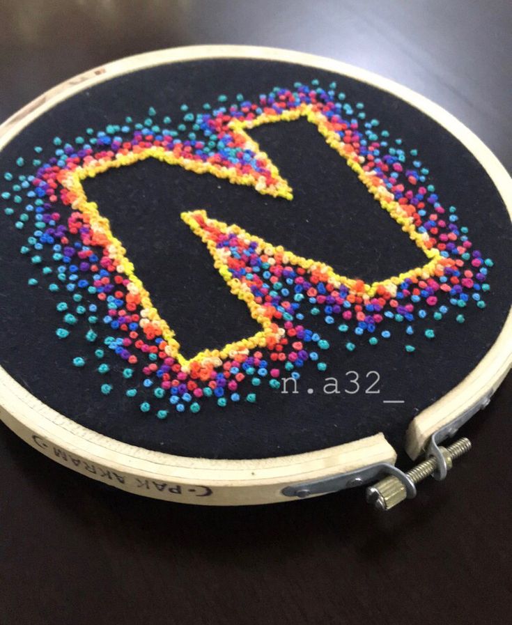 a cross stitch pattern with the letter m in multi - colored sprinkles