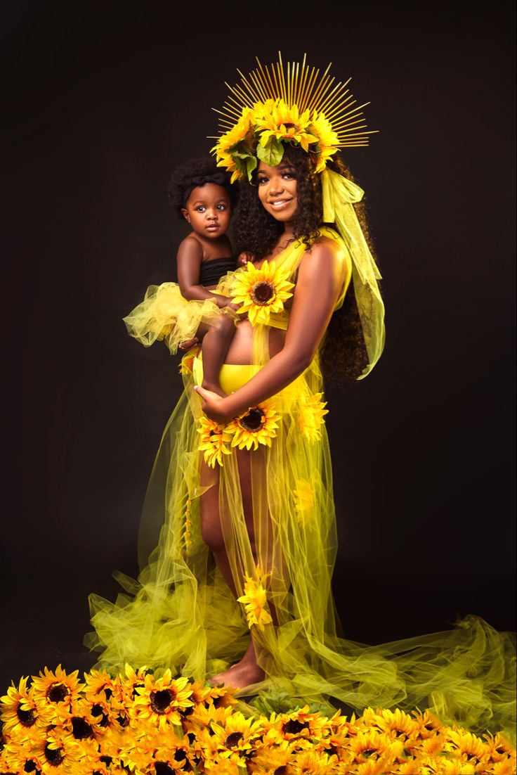 a woman and child dressed in yellow with sunflowers