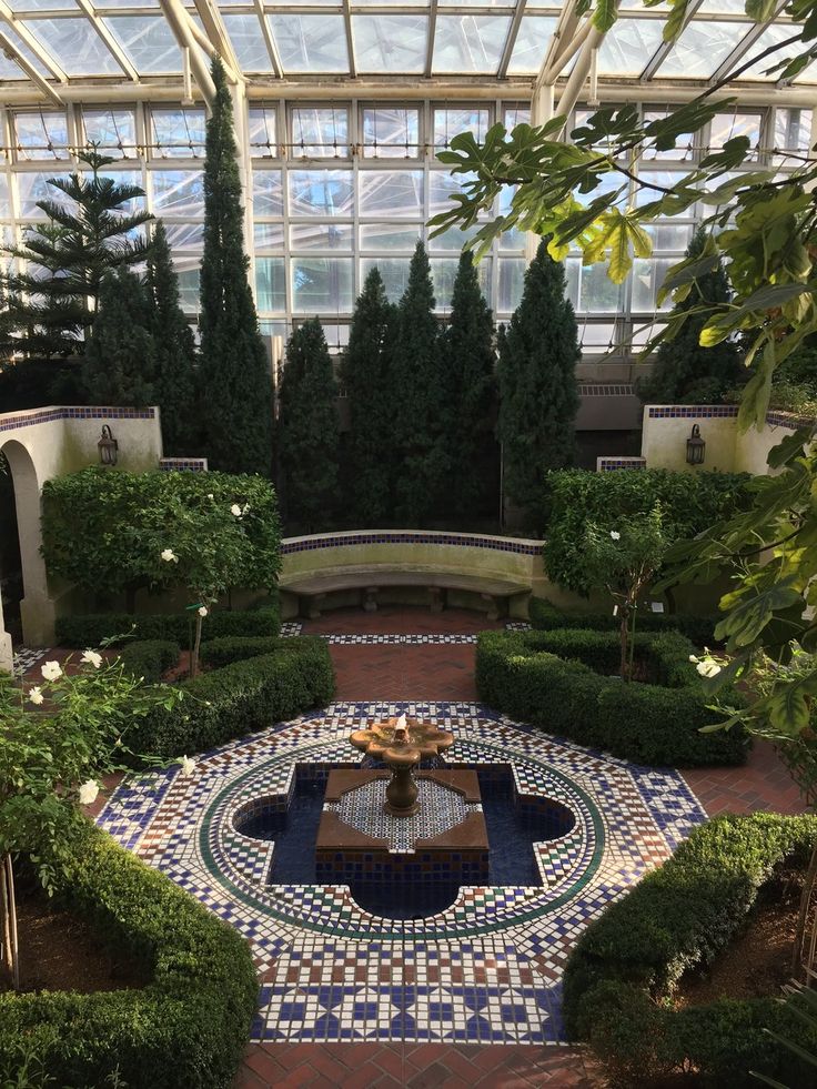 the inside of a building with many plants and trees in it's center area