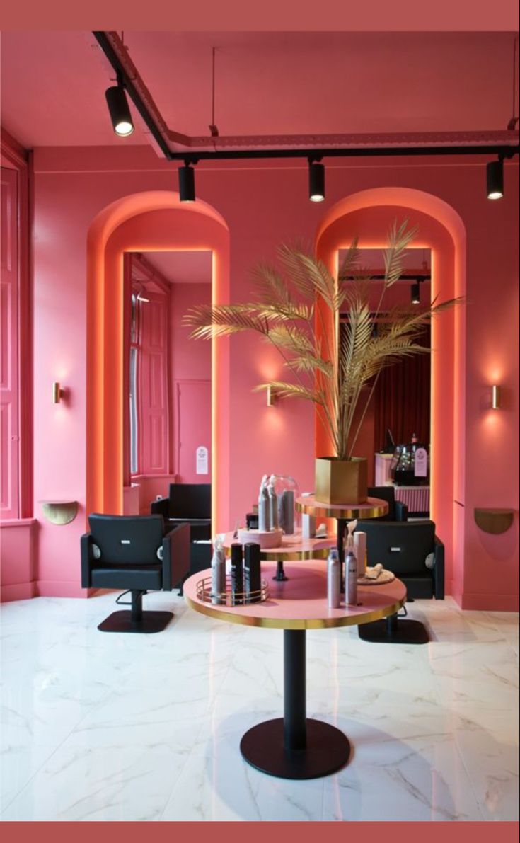 a pink room with black chairs and a plant in the center on a round table