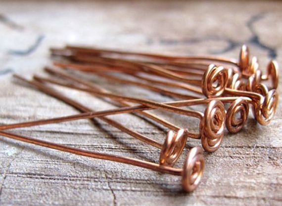 several copper colored pins sitting on top of a wooden table