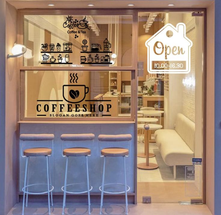 a coffee shop with three stools in front of the window and an open sign on the wall