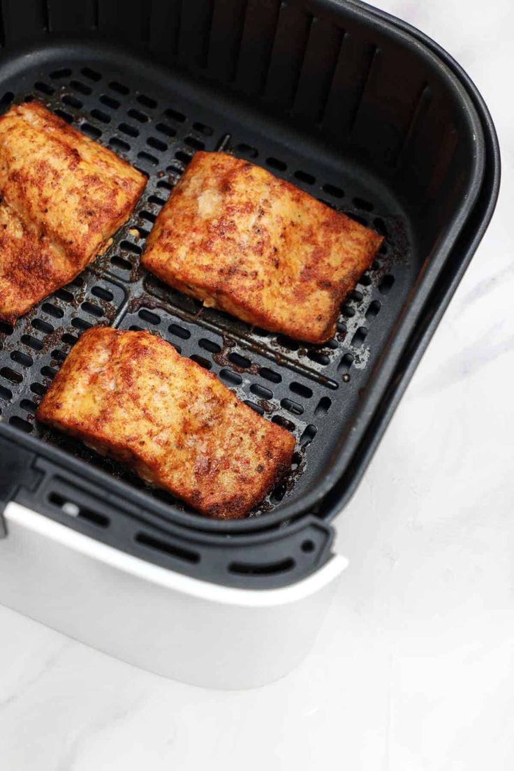 four square pieces of food cooking in an air fryer