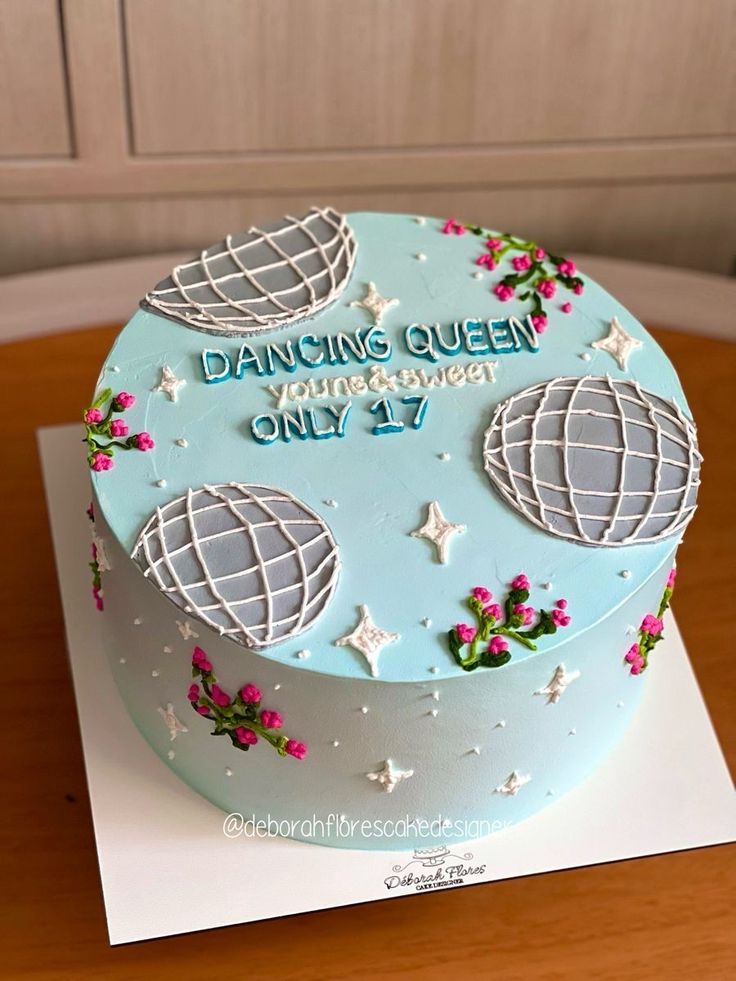 a birthday cake with blue frosting and stars on the top is sitting on a table