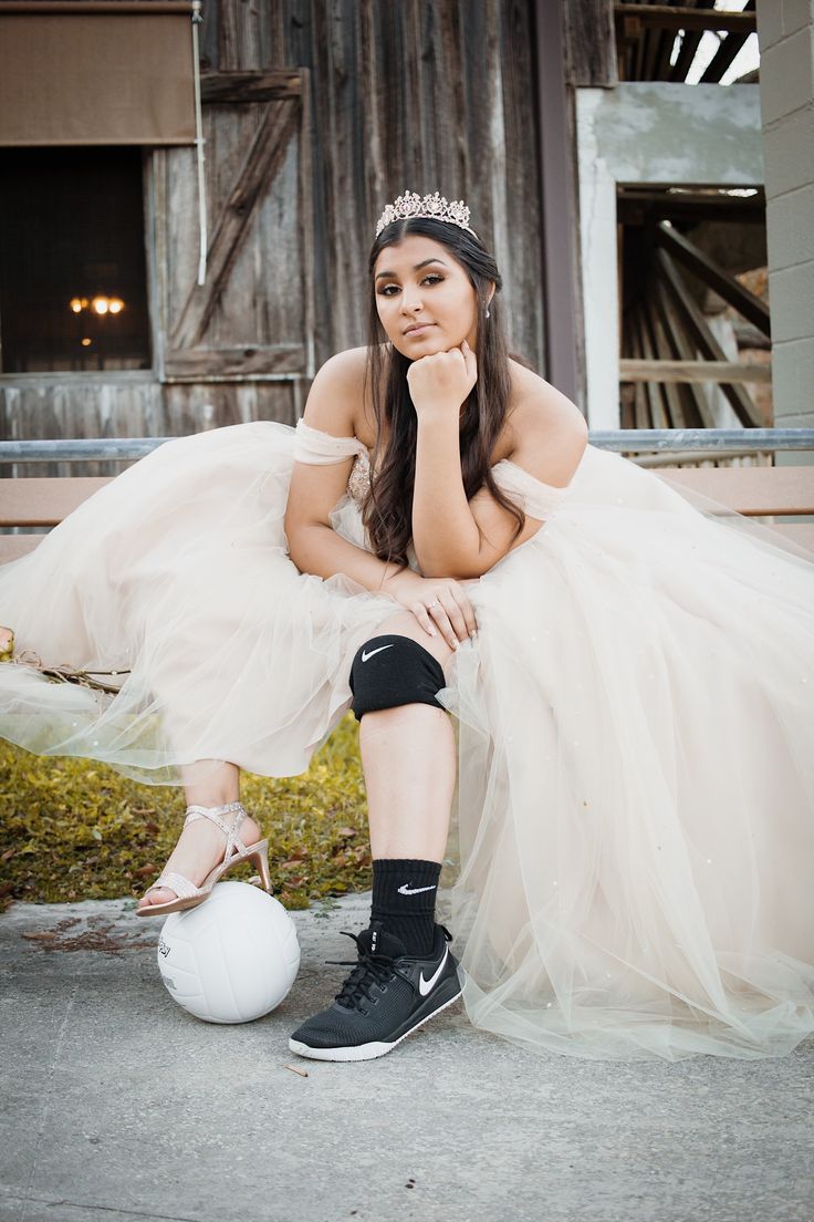 a woman sitting on the ground next to a ball wearing a tiara and shoes