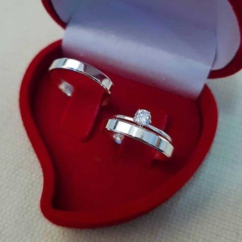 two wedding rings in a heart shaped box