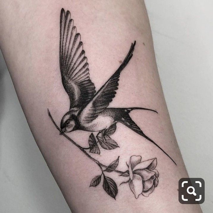 a small bird sitting on top of a branch next to a rose flower tattoo design