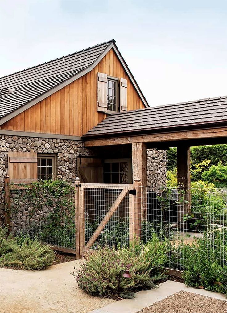 a wooden house with a metal fence around it