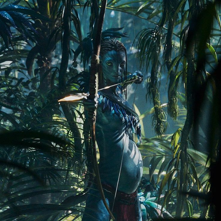 a woman in the jungle holding a bow and arrow