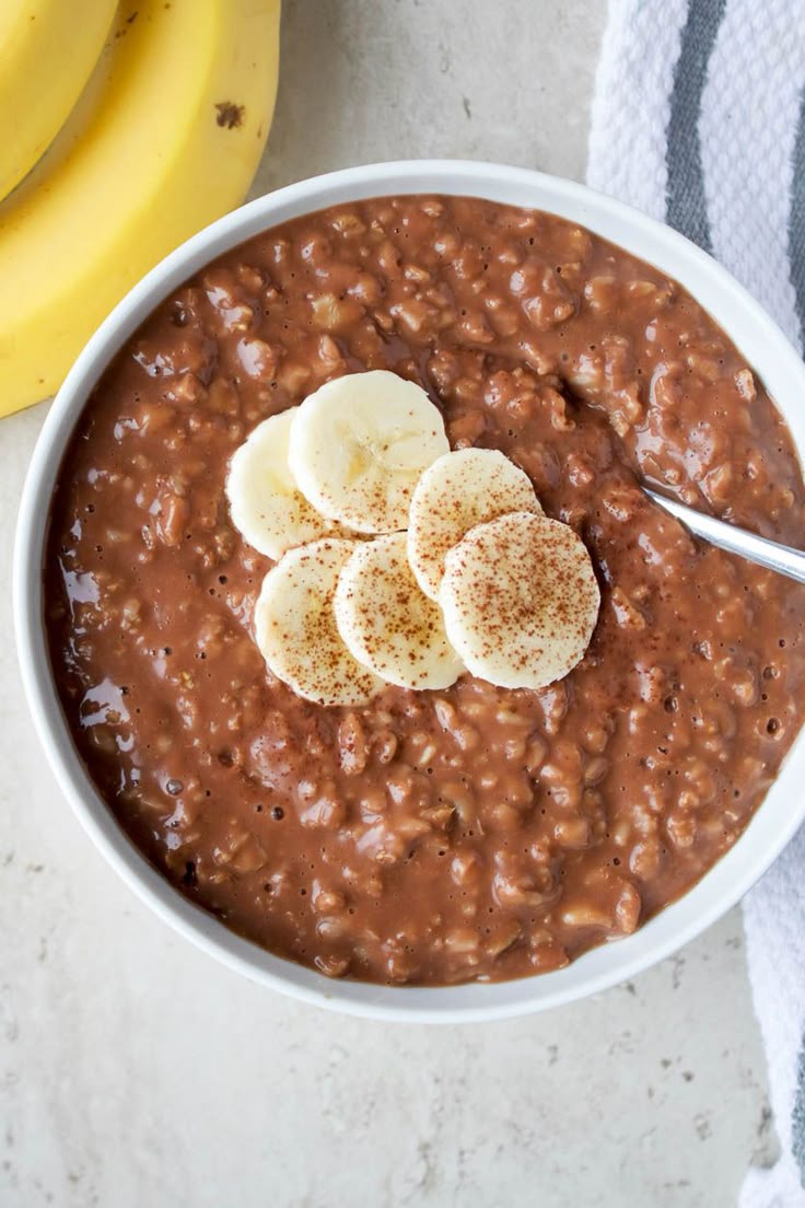 a bowl of chocolate pudding with bananas on the side