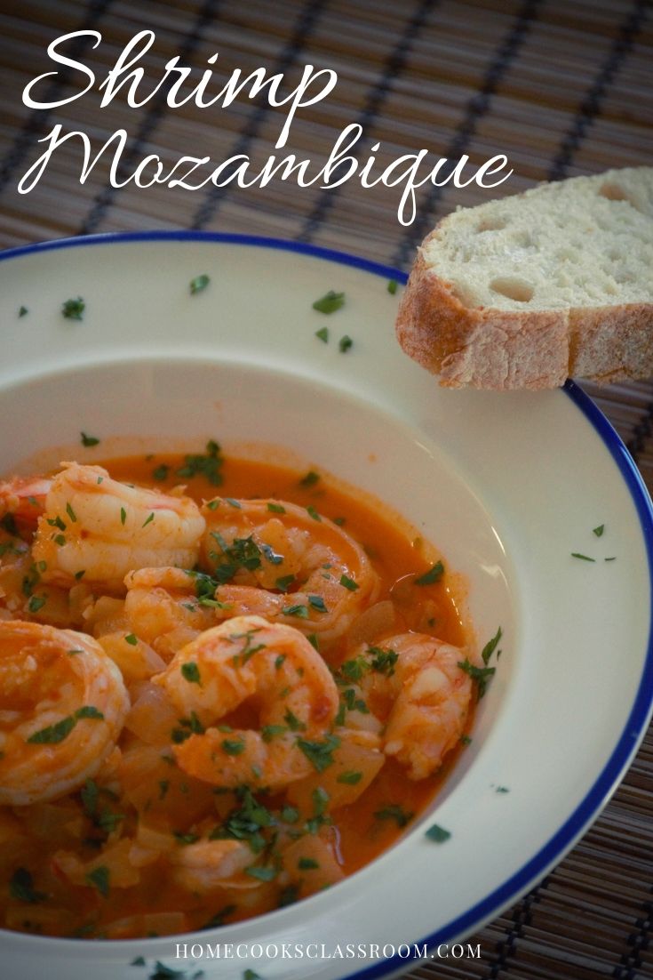 shrimp and noodle soup in a white bowl with bread on the side for garnish