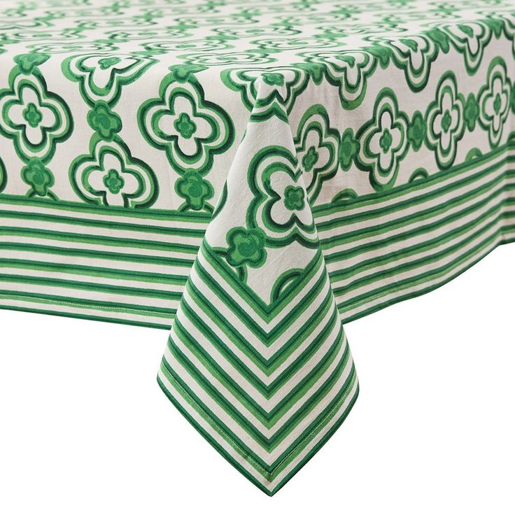 a green and white table cloth with flower designs on the top, along with matching napkins