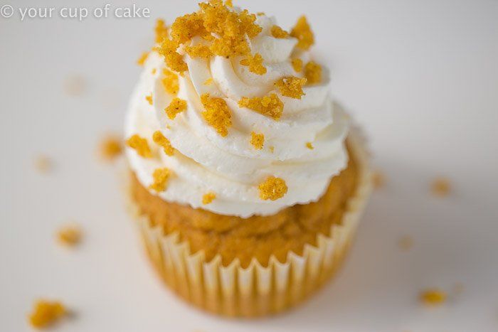 a cupcake with white frosting and orange sprinkles on it's top