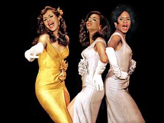 three women dressed in white and gold posing for the camera