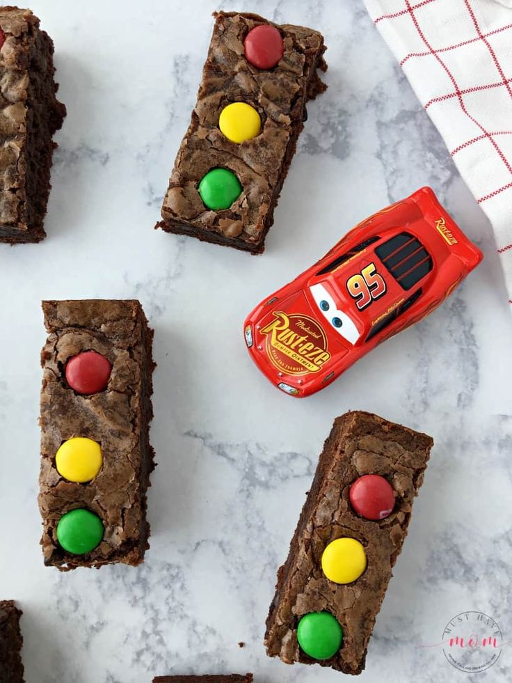 chocolate brownies with m & m candies and a candy bar on the side