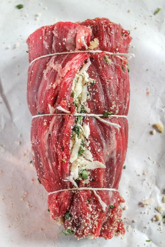 raw meat wrapped in wire on top of white paper