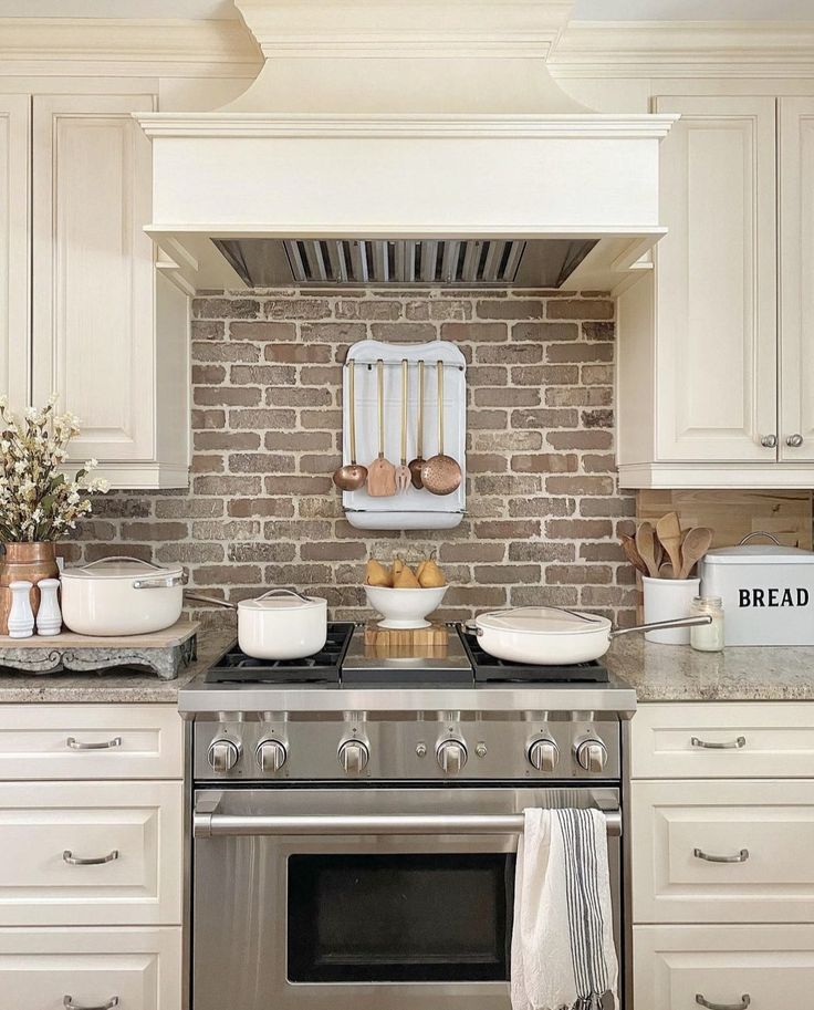 a stove top oven sitting inside of a kitchen next to white cabinets and counter tops