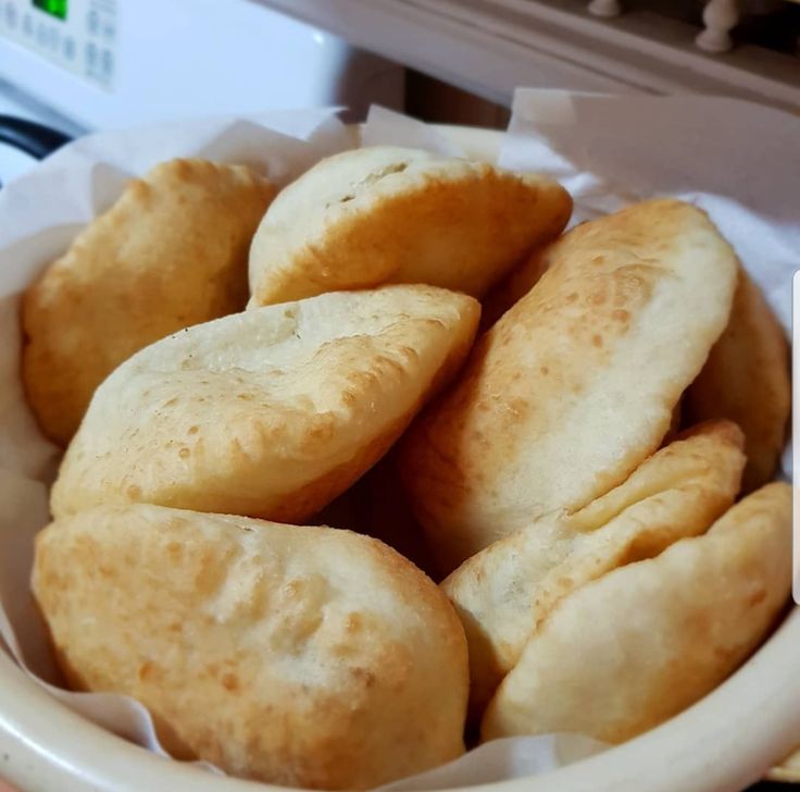 a bowl filled with bread sitting on top of a counter next to a microwave oven