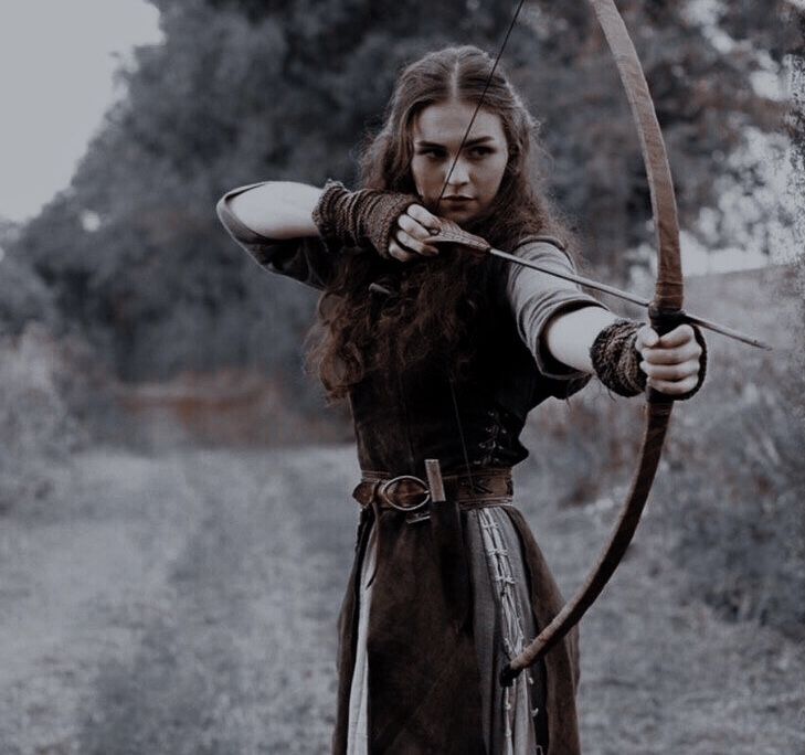 a woman with long hair holding a bow and arrow