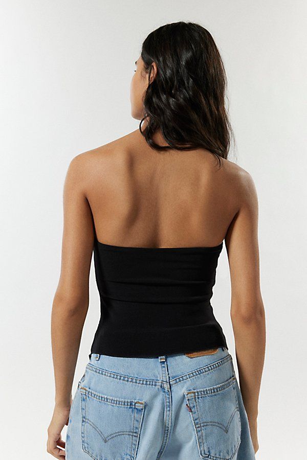 Modern tube top from Silence + Noise. Cropped to the waist and fitted throughout with a strapless neckline and a pointed hemline. Topped with cutouts and o-ring hardware at the front. Exclusively at UO. Features Silence + Noise Caprice tube top Fitted bandeau top Soft and stretchy knit Strapless tube neckline Double o-ring and peek-a-boo cut-out bodice Asymmetric hanky hemline Slim body-skimming fit Cropped length Easy pull-on style UO Exclusive Content + Care 95% Polyester, 5% spandex Machine w Edgy Bandeau Tube Top For Club, Black Bandeau Tank Top For Club, Black Strapless Stretch Halter Top, Edgy Strapless Tube Top For Night Out, Black Fitted Bandeau Halter Top, Black Bandeau Halter Top, Chic Strapless Tops For Club, Bandeau Halter Top For Clubbing, Fitted Bandage Bandeau Tube Top