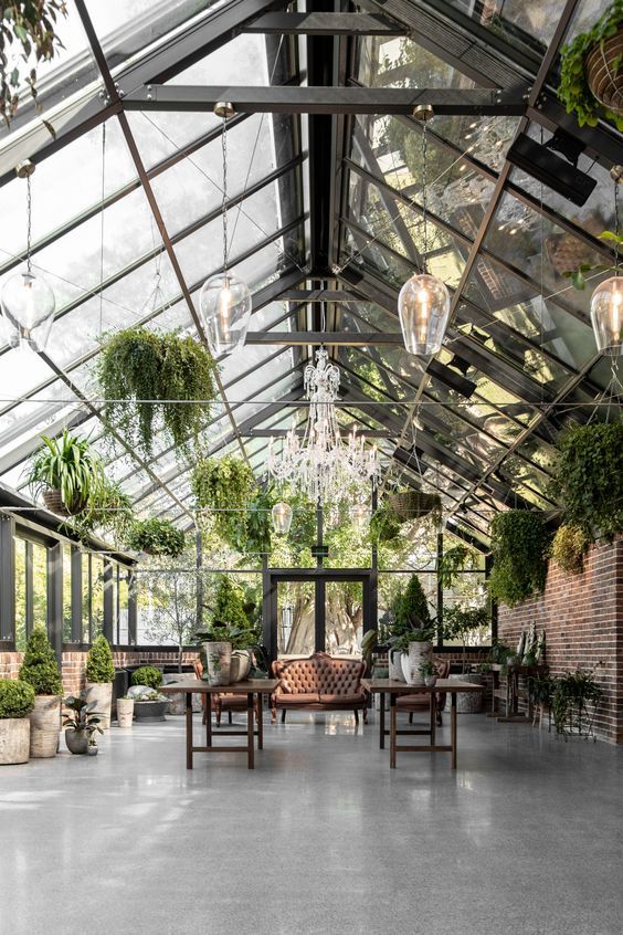 the inside of a greenhouse with potted plants and chandeliers