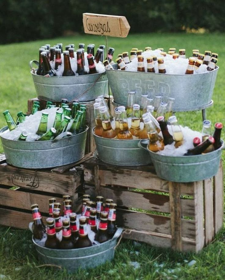 an assortment of beer bottles in buckets on the grass