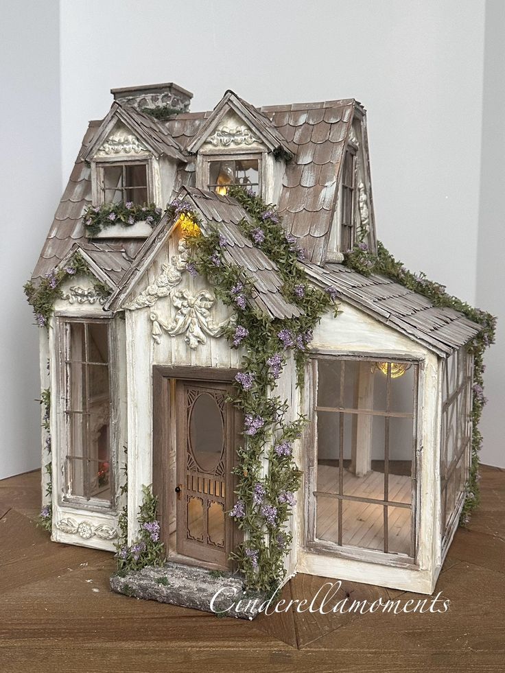 a doll house made out of wood with ivy growing on it's roof and windows