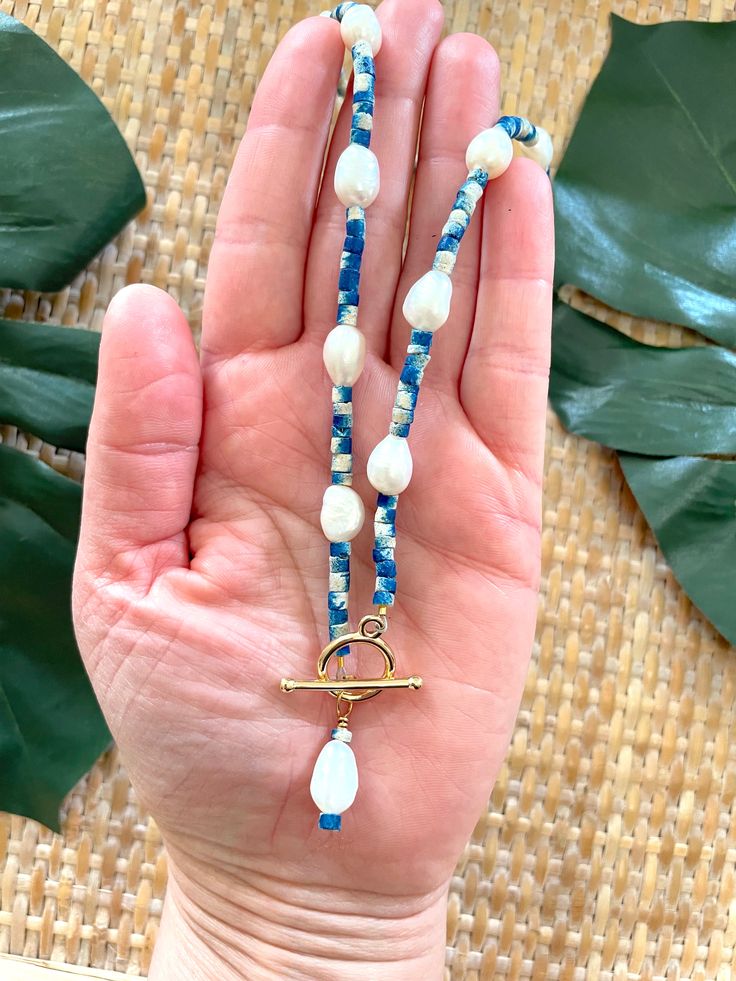 Welcome to our Coastal Inspired Beaded Pearl Necklace – a stunning blend of elegance and coastal charm, inspired by the breathtaking coastline of Santorini, Greece! 🌊✨Crafted with care and attention to detail, this necklace features a beautiful combination of unique tie-dyed bright blue and white coconut shell heishi beads, reminiscent of the colors of the Aegean Sea, and lustrous 9mm freshwater pearls. Each bead is carefully selected to evoke the serene beauty of Santorini's coastline, creatin African Beaded Bracelets, Beaded Pearl Necklace, Unique Ties, Blue Sodalite, Coastal Charm, Coral And Gold, Aegean Sea, Red Turquoise, African Beads