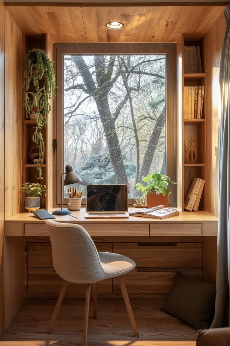 a desk with a laptop on it in front of a window and bookshelf