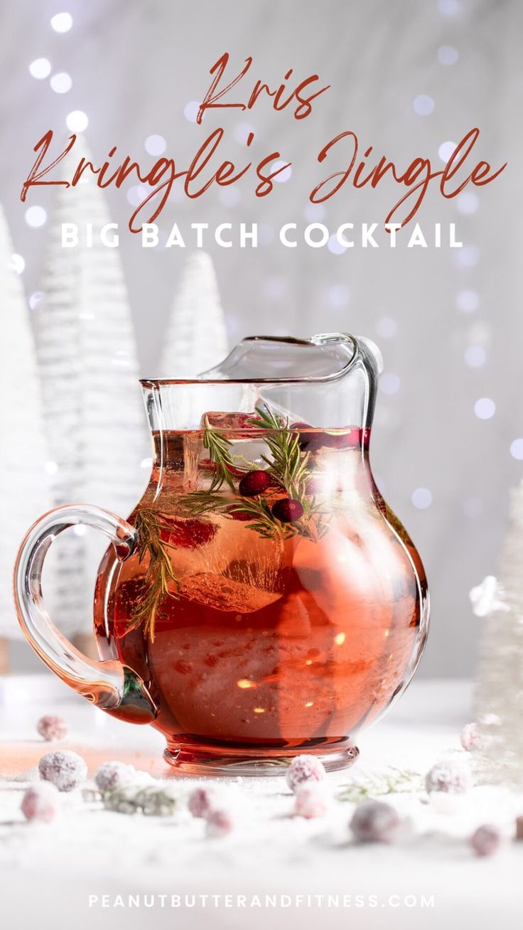 a glass pitcher filled with liquid next to christmas trees