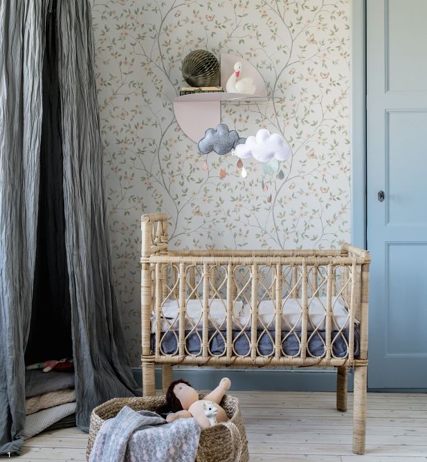 a baby's room with a crib, bed and wall papered walls