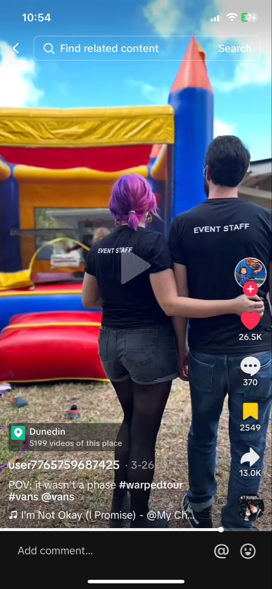 two people standing next to each other in front of an inflatable bounce house