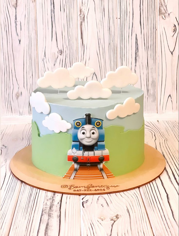 a thomas the train birthday cake on a wooden table