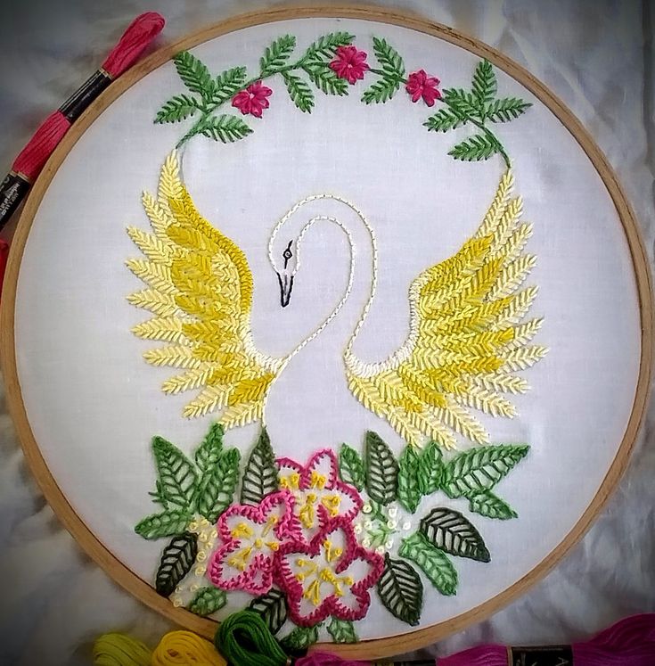 a white swan with yellow wings and pink flowers