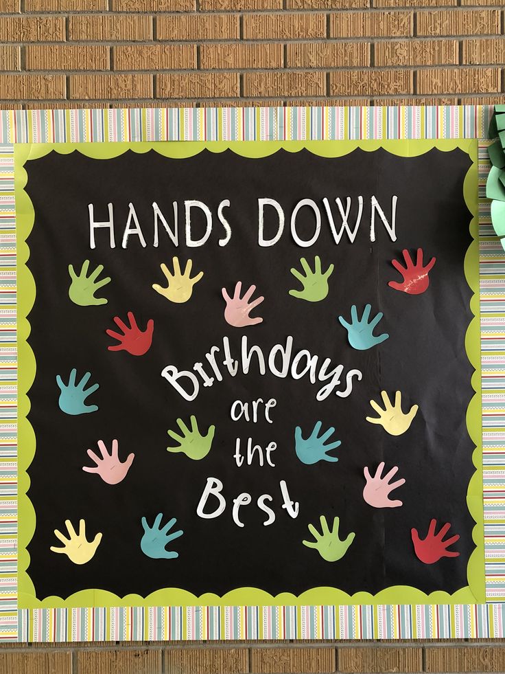 a sign that says hands down birthdays are the best on a brick wall with colorful hand prints