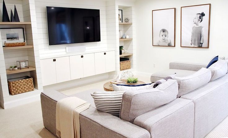 a living room filled with furniture and a flat screen tv mounted to the side of a wall