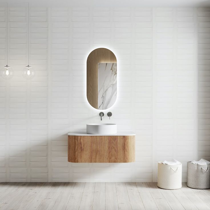 a white bathroom with a wooden vanity and round mirror on the wall next to it