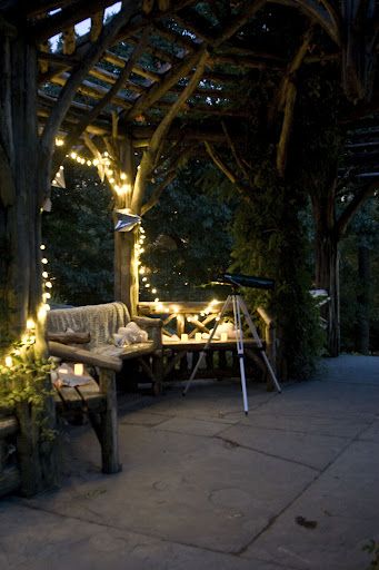 an outdoor seating area is lit up with fairy lights