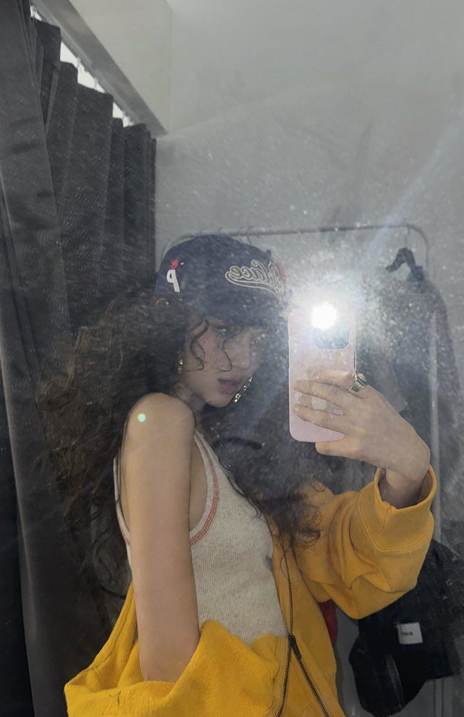 a woman taking a selfie in front of a mirror