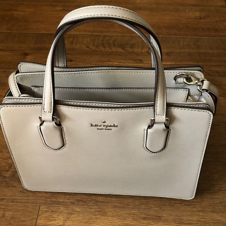 Beautiful (Nwt) Kate Spade Light Gray Leather Satchel Handbag! Two Handles & A Detachable Strap, Silver Hardware, Zipped Top Closure, Two Large Snapped Side Pockets, 3d “Kate Spade” On Front, Bottom Studs. Measures-12l X 8.5h X 5d Open To Reasonable Offers Only. Please Give Best Offer, Not Lowest Offer Bundle & Save $$ Thank You For Looking! No Trades Please. Packages Ship Daily Mon.-Fri., Sometimes On Saturdays. Please Be Patient As My Post Office Is Sometimes Slow Classic Silver Shoulder Bag With Removable Pouch, Elegant Gray Rectangular Satchel, Classic Silver Tote Shoulder Bag, Elegant Gray Satchel With Top Carry Handle, Classic Silver Bag For Everyday Use, Classic Silver Bag For Daily Use, Elegant Gray Double Handle Satchel, Silver Leather Satchel With Top Carry Handle, Classic Silver Satchel For Everyday Use