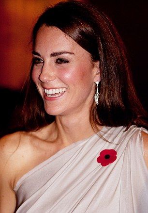 a woman in a white dress smiling and wearing a red flower on her left shoulder